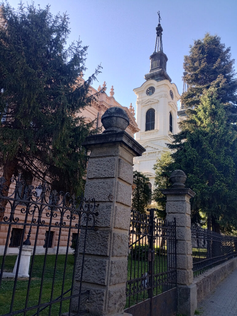 pogled peko ograde na beli crkveni objekat sa tornjem